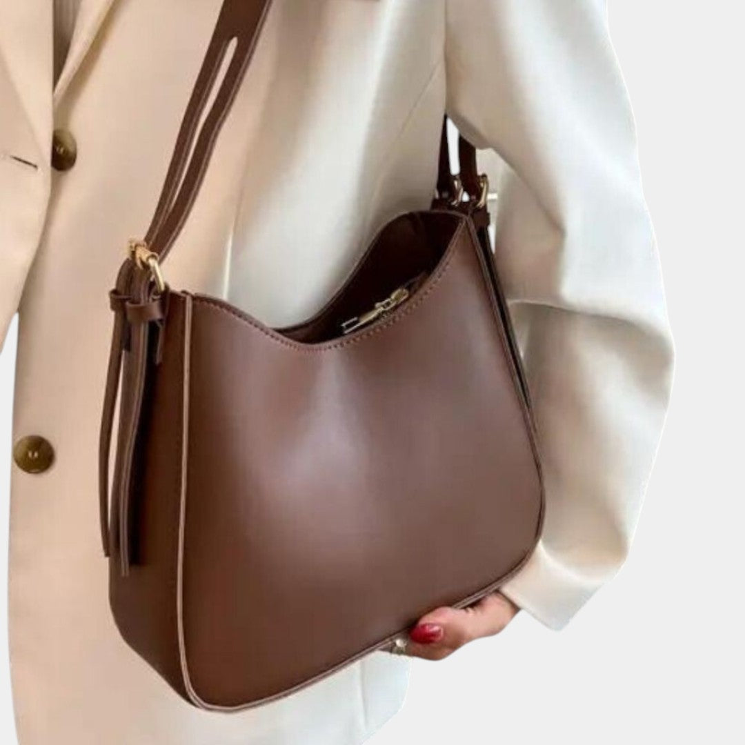 Minimalist faux leather crossbody bag for women in soft tones, featuring a slim silhouette and roomy interior for daily essentials
