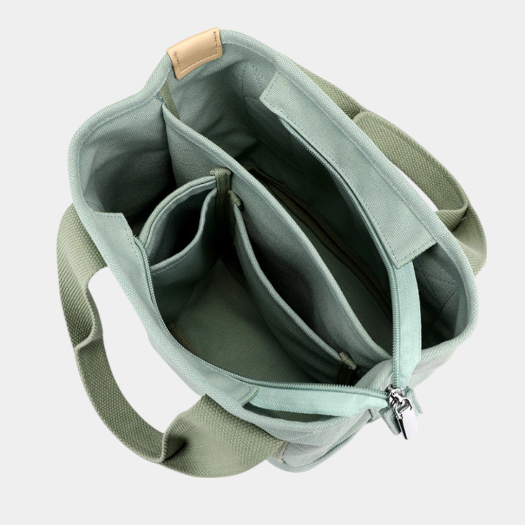 Women’s stylish canvas shoulder bag with adjustable strap and multiple compartments, perfect for everyday use